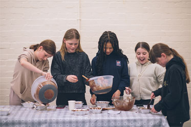 Youth club members baking cakes