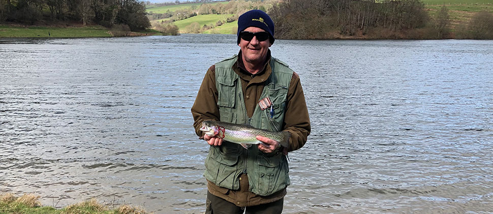 Man Smiling Whilst Holding A Fish