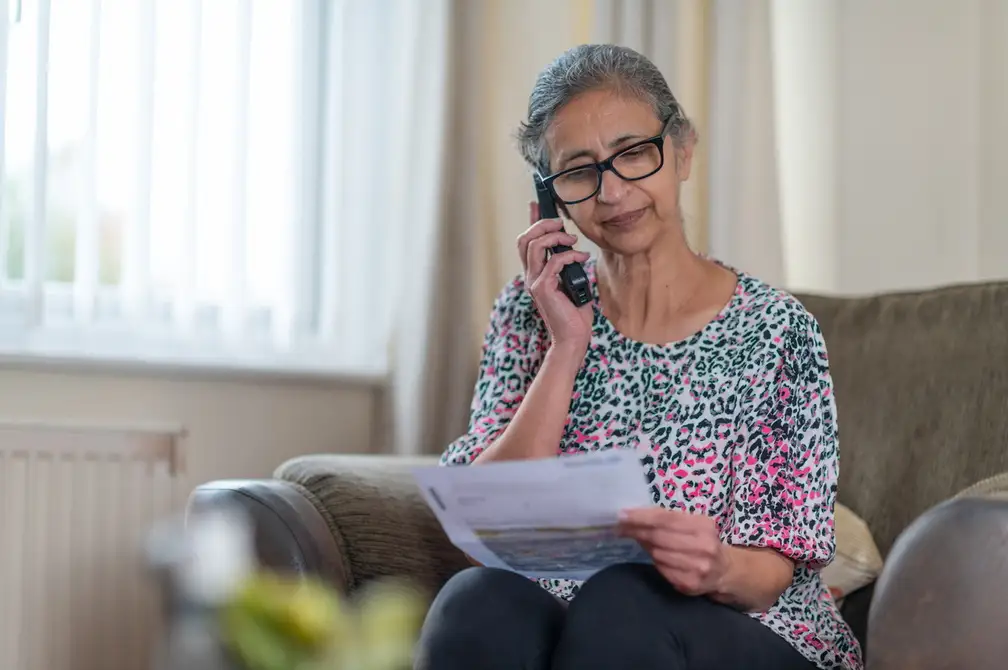 Customer talking on the phone while holding a bill