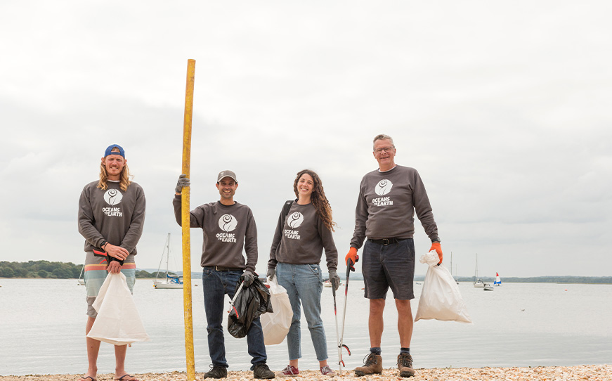 Oceans To Earth Volunteers cleaning a beach