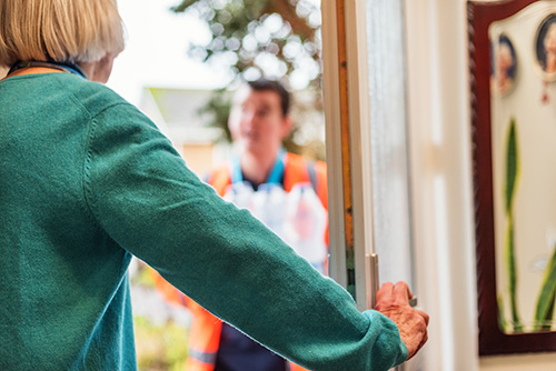 Elderly customer answering the door to a wessex water employee