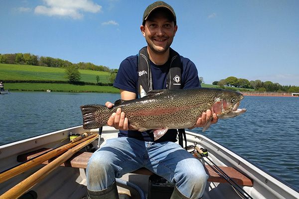 Man In A Boat At Hawkridge Holding A Fish