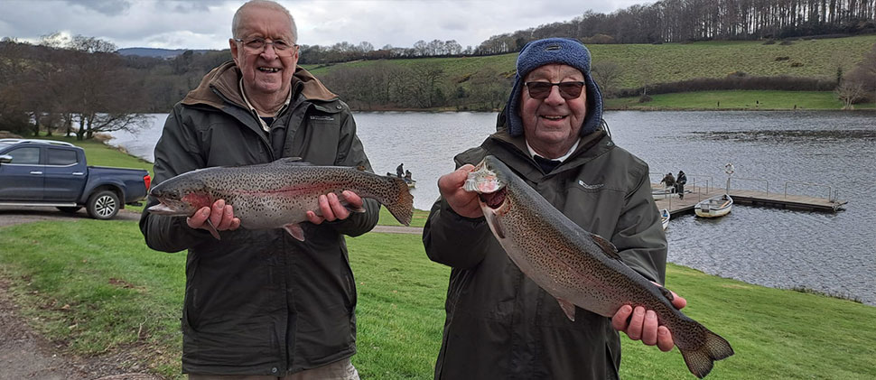 Two men holding fishes